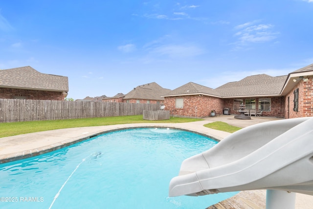 view of swimming pool featuring a fenced backyard, a fenced in pool, a yard, and a patio area
