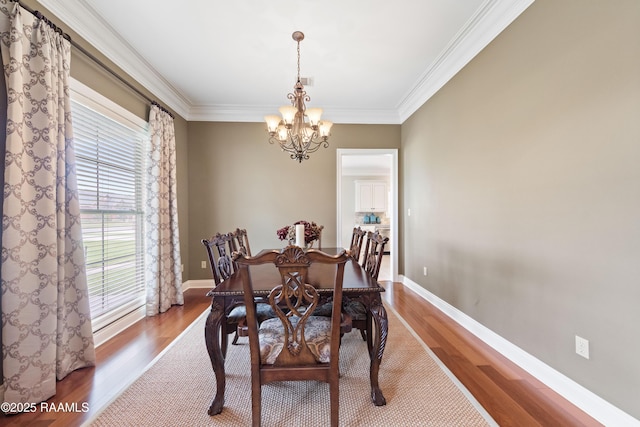dining room with an inviting chandelier, ornamental molding, and wood finished floors