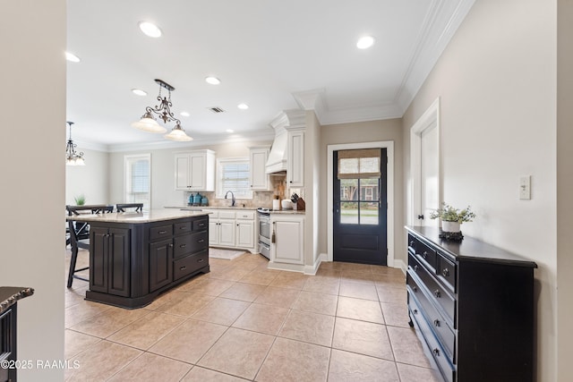 kitchen featuring a kitchen bar, custom range hood, ornamental molding, stainless steel range with electric cooktop, and white cabinets