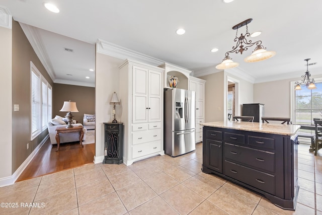 kitchen featuring light tile patterned flooring, white cabinetry, stainless steel refrigerator with ice dispenser, and crown molding