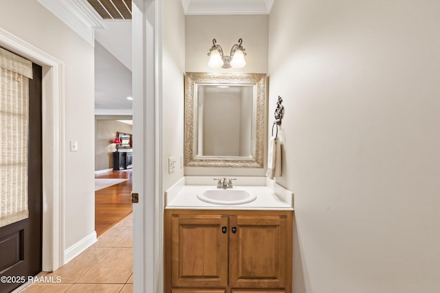 bathroom featuring visible vents, baseboards, ornamental molding, vanity, and tile patterned flooring