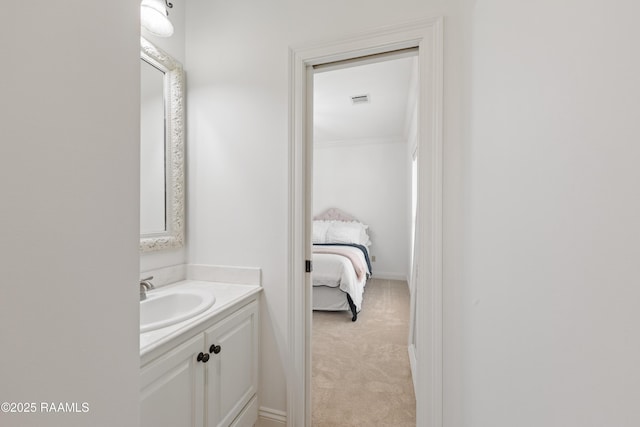 ensuite bathroom with baseboards, ensuite bath, visible vents, and vanity