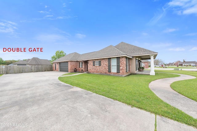 view of front of property featuring driveway, a front yard, fence, brick siding, and a garage