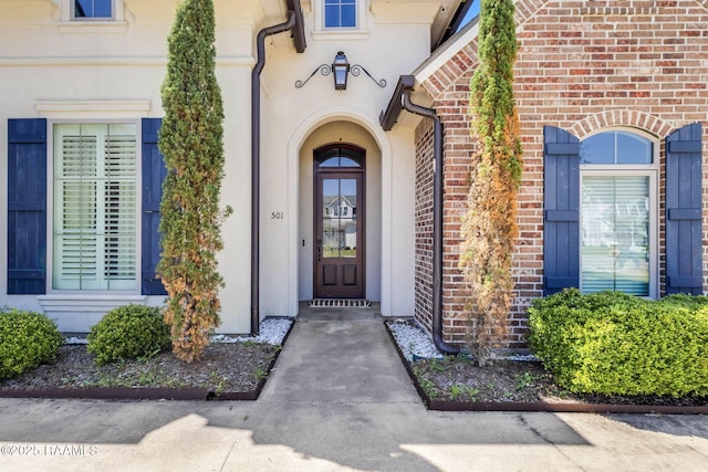 doorway to property featuring brick siding