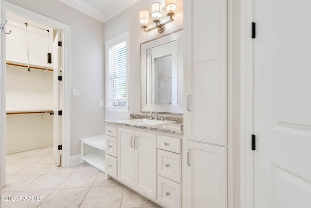 bathroom featuring baseboards, a spacious closet, tile patterned flooring, vanity, and ornamental molding