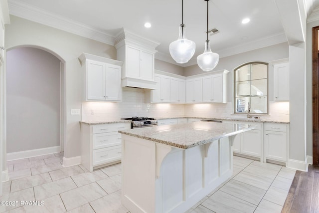 kitchen with backsplash, visible vents, gas stove, and white cabinetry