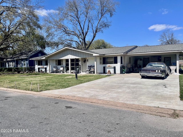 ranch-style house with driveway, an attached carport, and a front lawn