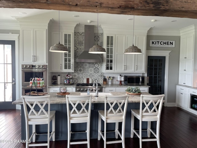 3713 Vidrine Rd, Ville Platte, LA 70586 - kitchen featuring wall chimney exhaust hood, appliances with stainless steel finishes, backsplash, dark wood-style floors, and white cabinetry