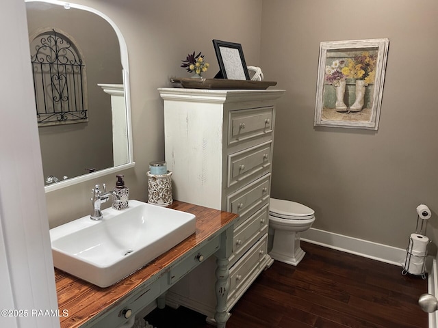 3713 Vidrine Rd, Ville Platte, LA 70586 - bathroom featuring wood finished floors, toilet, baseboards, and vanity