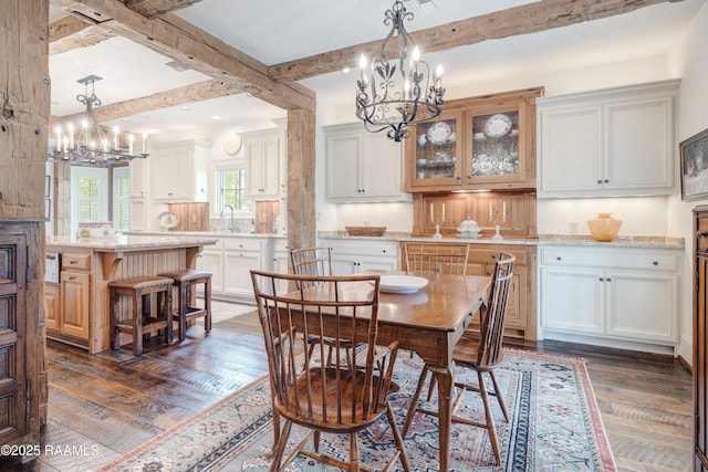 dining area featuring beam ceiling, a notable chandelier, and dark wood-style floors