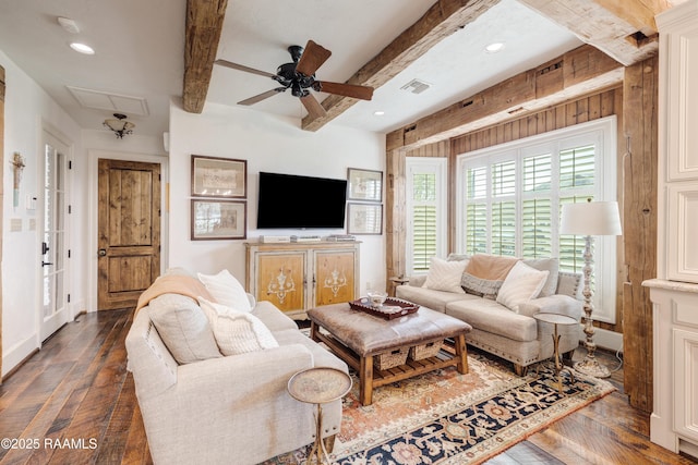 living room with a ceiling fan, visible vents, beam ceiling, attic access, and wood-type flooring