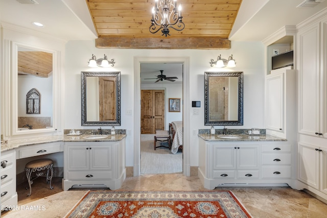 ensuite bathroom with wooden ceiling, two vanities, ceiling fan with notable chandelier, and a sink