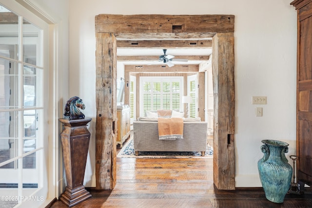 hall with hardwood / wood-style flooring, baseboards, and beam ceiling