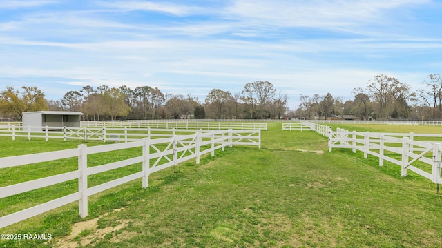 view of yard with an outdoor structure, a rural view, and an exterior structure