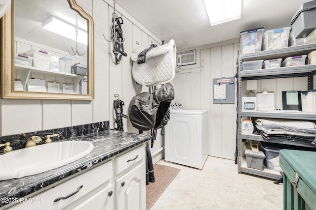 interior space featuring laundry area, washer / dryer, an AC wall unit, and a sink