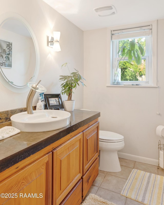 907 Omega Dr, Lafayette, LA 70506 - bathroom with tile patterned floors, visible vents, toilet, baseboards, and vanity