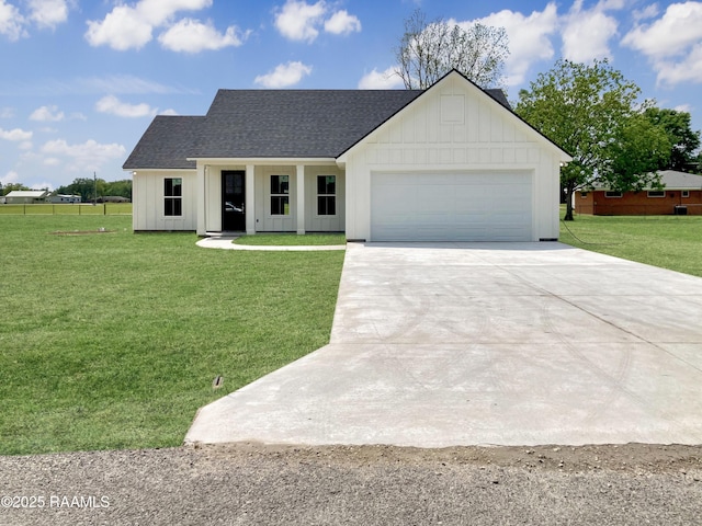 view of front of property featuring concrete driveway, a front lawn, board and batten siding, a garage, and roof with shingles