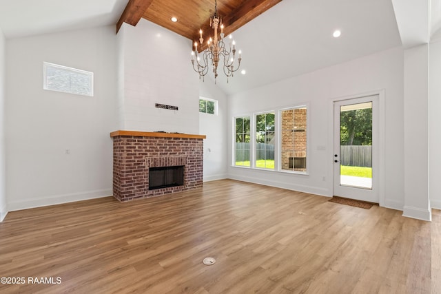 303 Canary Palm Way, Youngsville, LA 70592 - unfurnished living room with beamed ceiling, light wood-style flooring, high vaulted ceiling, a brick fireplace, and a chandelier