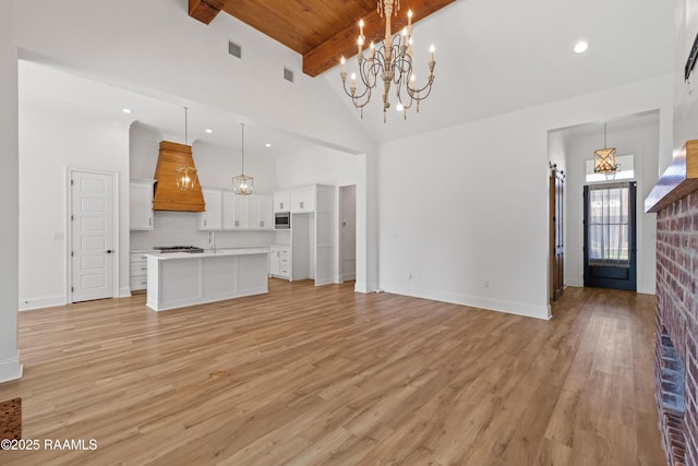 303 Canary Palm Way, Youngsville, LA 70592 - unfurnished living room with a chandelier, high vaulted ceiling, light wood finished floors, radiator, and beamed ceiling