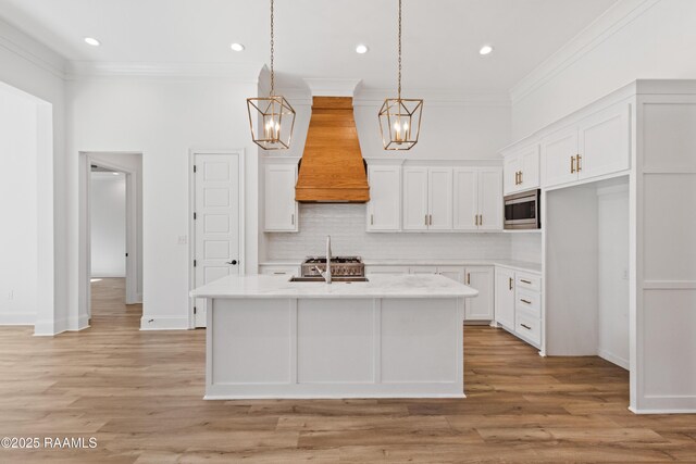 303 Canary Palm Way, Youngsville, LA 70592 - kitchen featuring a chandelier, stainless steel microwave, custom exhaust hood, backsplash, and crown molding