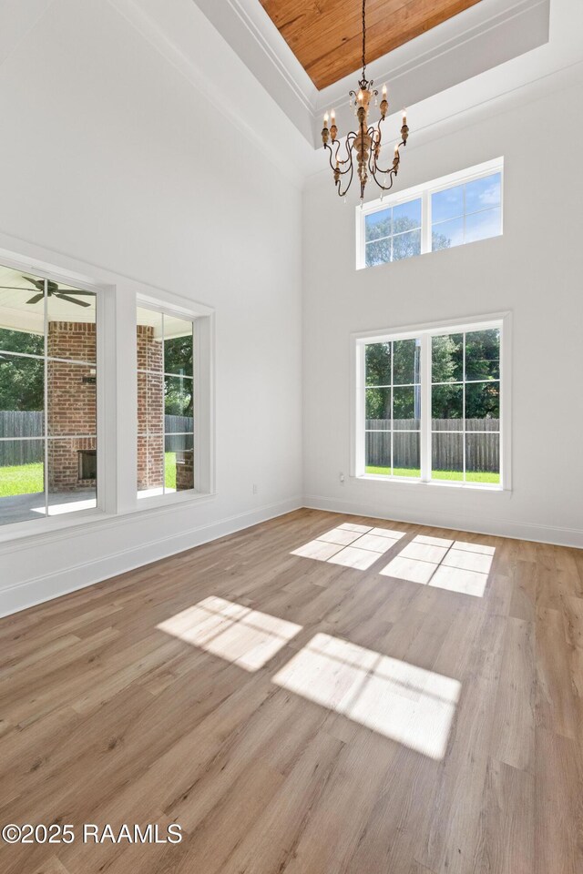 303 Canary Palm Way, Youngsville, LA 70592 - unfurnished room featuring a chandelier, a high ceiling, wood finished floors, a raised ceiling, and wooden ceiling
