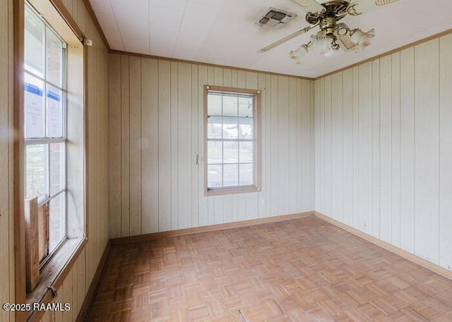 1010 Dugas Ln, Saint Martinville, LA 70582 - spare room featuring plenty of natural light, baseboards, a ceiling fan, wooden walls, and crown molding