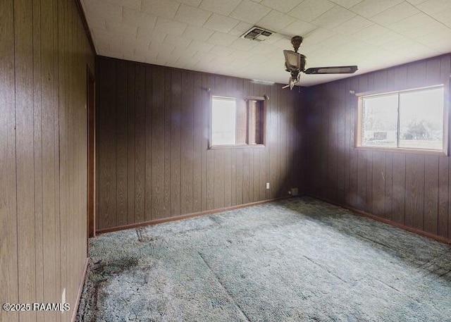 1010 Dugas Ln, Saint Martinville, LA 70582 - unfurnished room with healthy amount of natural light, carpet floors, a ceiling fan, and wooden walls