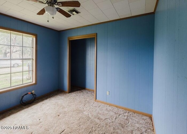 1010 Dugas Ln, Saint Martinville, LA 70582 - spare room with carpet, a ceiling fan, wooden walls, and crown molding