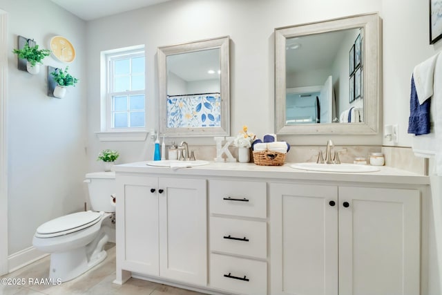 full bath featuring a sink, toilet, double vanity, and tile patterned flooring