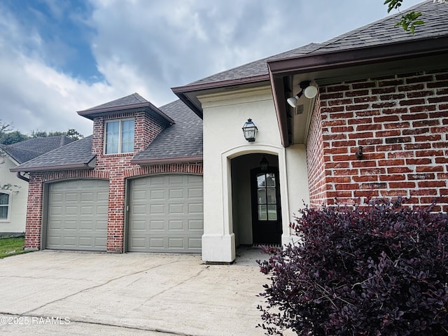 205 Lo Saab Cv, Lafayette, LA 70506 - doorway to property featuring brick siding, roof with shingles, a garage, and concrete driveway