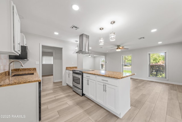 kitchen with visible vents, a ceiling fan, electric range, island exhaust hood, and a sink
