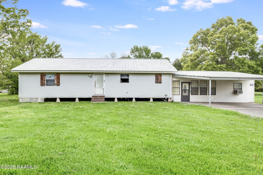 4812 Meadowcrest Dr, New Iberia, LA 70560 - rear view of property featuring metal roof, entry steps, an attached carport, a lawn, and cooling unit