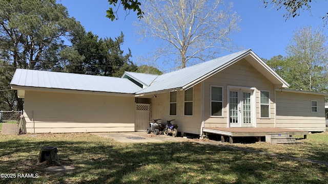 178 Wild Iris Dr, Evangeline, LA 70537 - view of front of home with fence, french doors, a wooden deck, a front yard, and metal roof