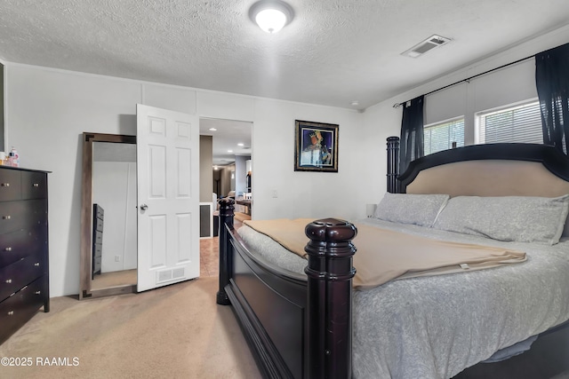 carpeted bedroom with a textured ceiling and visible vents