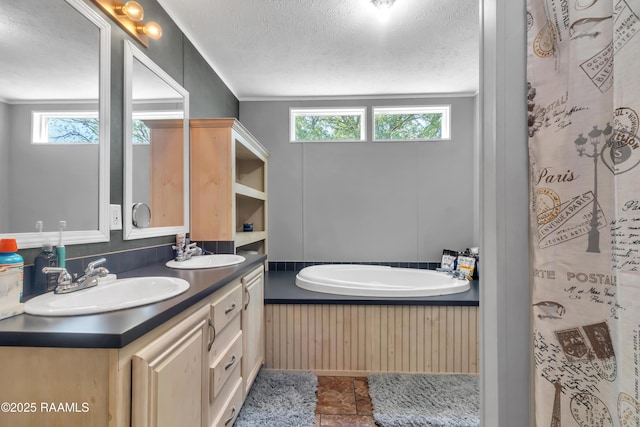 bathroom with a textured ceiling, a sink, and double vanity