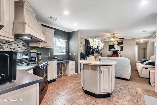 kitchen featuring black electric range oven, visible vents, premium range hood, open floor plan, and a ceiling fan