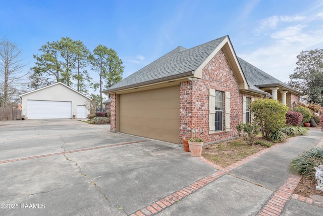 view of side of home with fence, brick siding, an outdoor structure, and a shingled roof