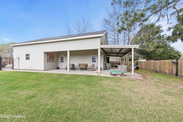 rear view of house with a patio area, a yard, fence, and an outdoor hangout area