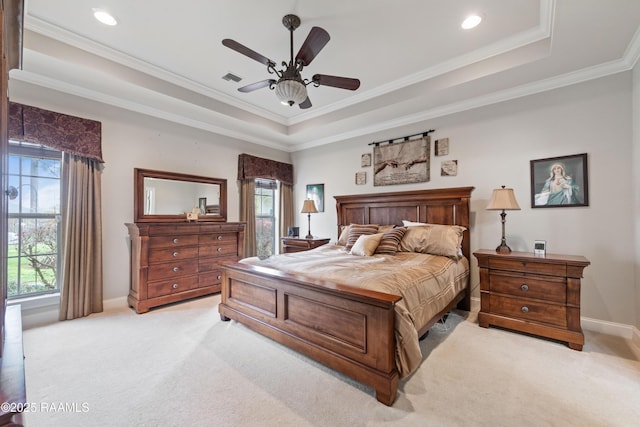 bedroom with baseboards, visible vents, a tray ceiling, ornamental molding, and light carpet