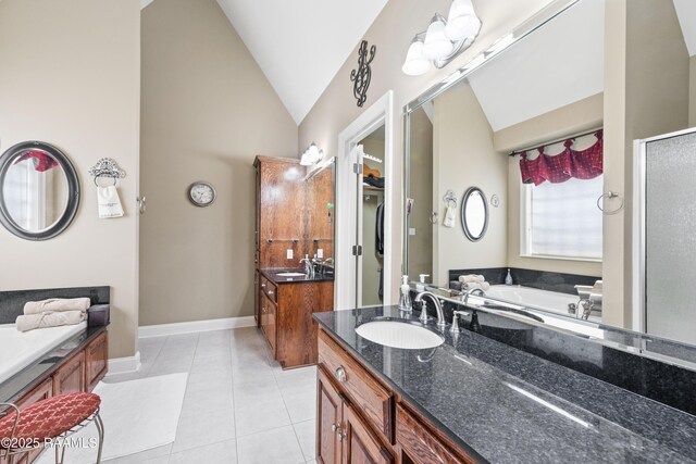 bathroom featuring a sink, two vanities, tile patterned flooring, and vaulted ceiling