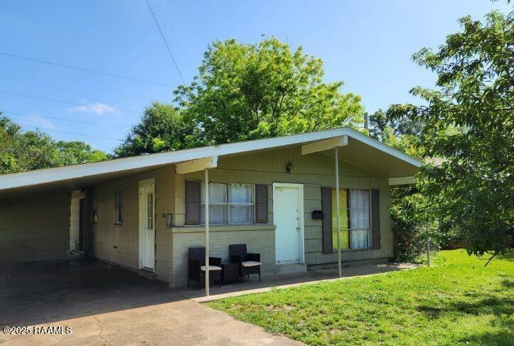 605 Choctaw Dr, Opelousas, LA 70570 - ranch-style house with a carport, concrete driveway, and a front lawn
