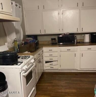 605 Choctaw Dr, Opelousas, LA 70570 - kitchen featuring white gas range, stainless steel microwave, white cabinets, and dark wood finished floors