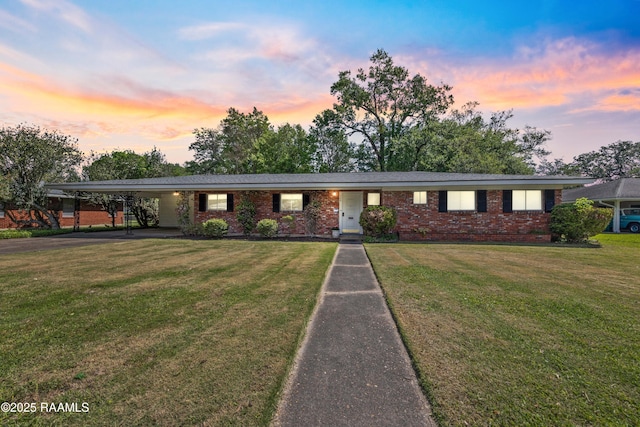 300 W Saint Louis St, Lafayette, LA 70506 - view of front of property with brick siding, a carport, driveway, and a lawn