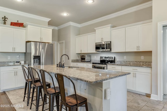 114 Marigold Ln, Maurice, LA 70555 - kitchen with a breakfast bar area, crown molding, a sink, an island with sink, and appliances with stainless steel finishes