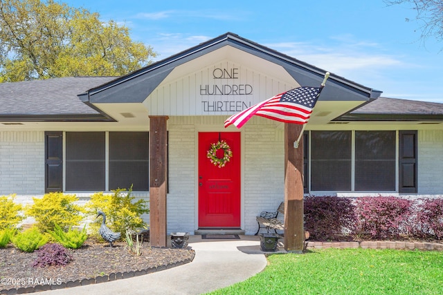 property entrance with brick siding and roof with shingles