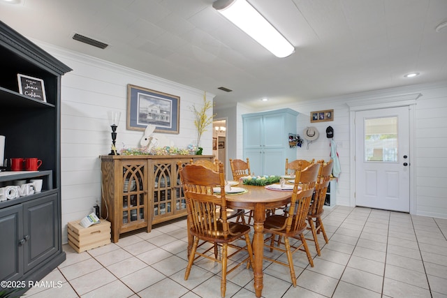 dining space featuring light tile patterned flooring, ornamental molding, and visible vents
