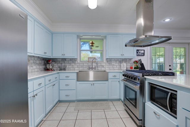 kitchen featuring high end range, light countertops, island exhaust hood, ornamental molding, and a sink