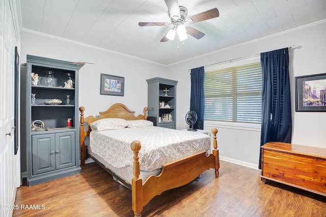 bedroom with a ceiling fan, crown molding, and wood finished floors