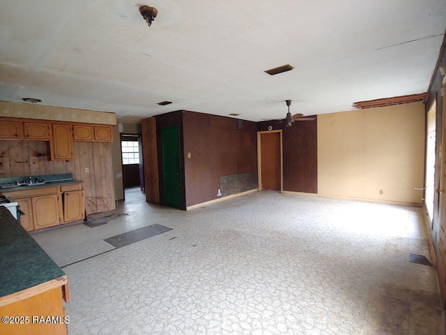 802 Myrtis St, New Iberia, LA 70560 - unfurnished living room featuring a ceiling fan, wood walls, and baseboards