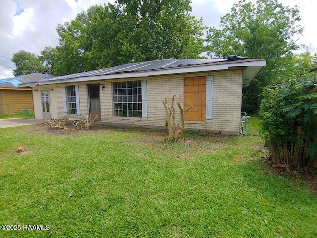 802 Myrtis St, New Iberia, LA 70560 - view of front of home featuring a front lawn, brick siding, and solar panels
